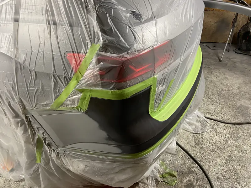 A bumper masked with tape and film, ready for paint