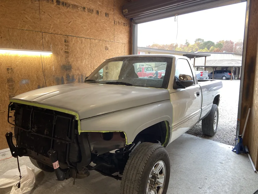 A Dodge pickup in primer, prepped for paint in the bay